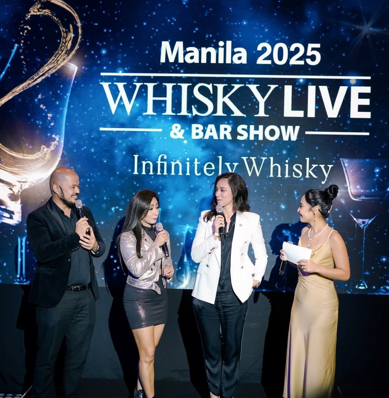 Hosts on stage in front of the Whisky Live Manila & Bar Show backdrop