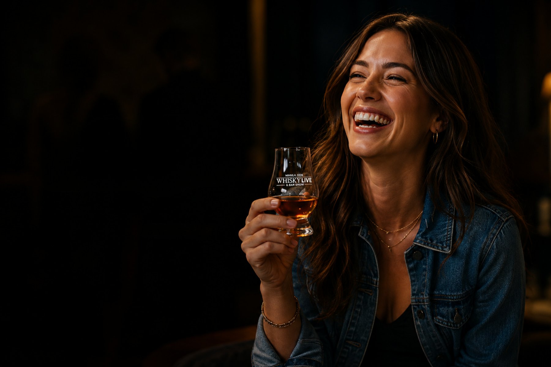 A guest laughing over a glass at Whisky Live